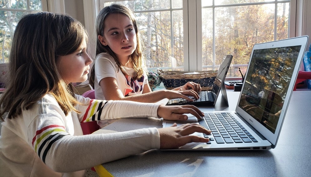 Friends coding on their computers