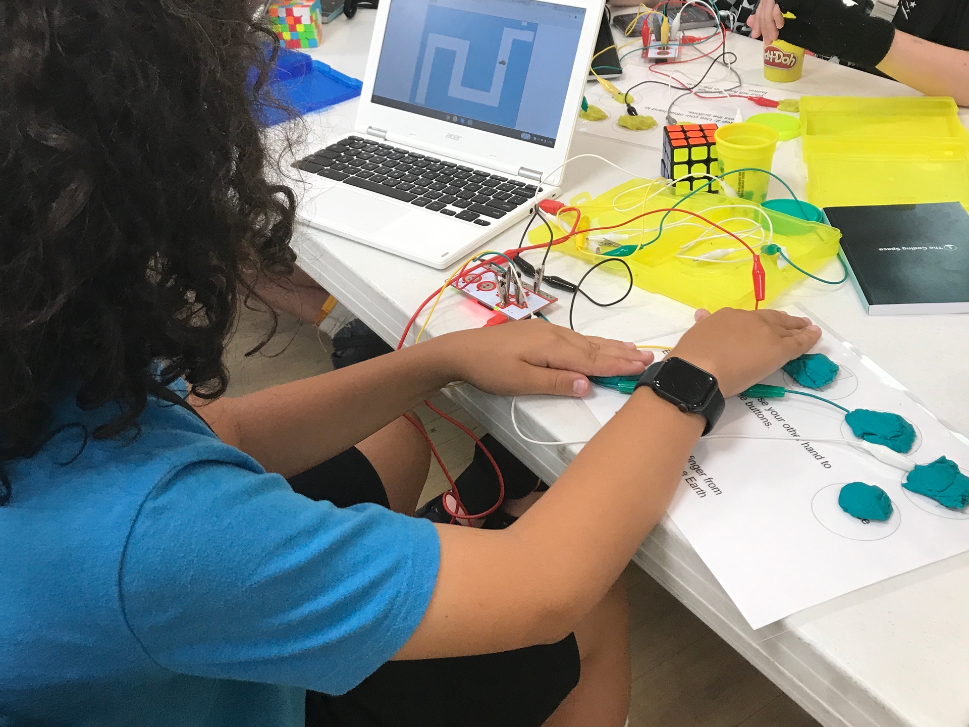 Kid coding at long table