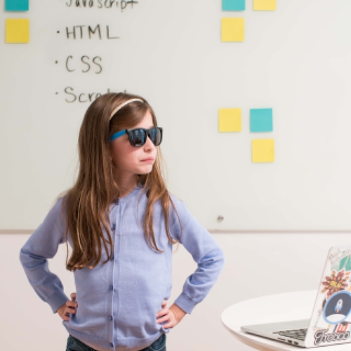 A young girl in coding classes in the appearance of a superhero.
